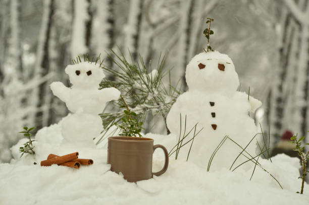 istock Cup of coffee on the snow with snowmans 1146971076