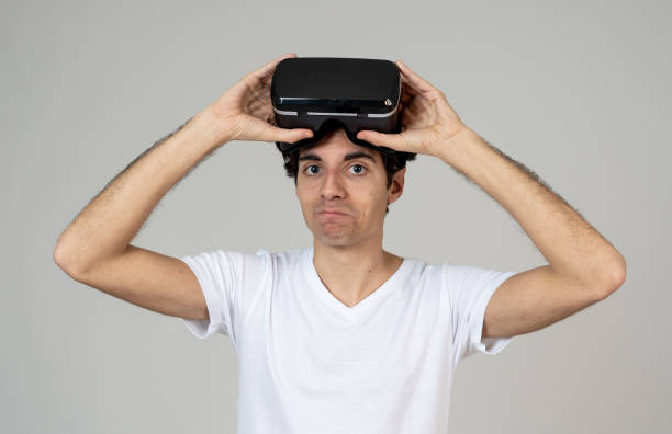 istock VR experience. Amazed and excited man using 360 VR headset goggles, feeling excited about simulation, making gestures having fun interacting with new virtual world. In Innovation and new technology. 1146973045