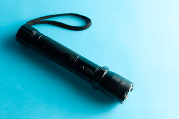 istock A black metal flashlight with shocker at the blue background. protection and security concept. for design and decoration. 1146974435