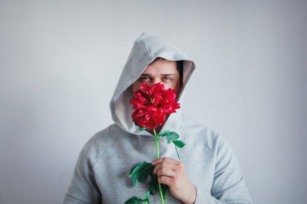 istock hesitate man with Peony flower on gray background 1146975326