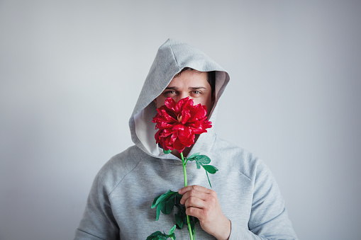 hesitate man with Peony flower on gray background