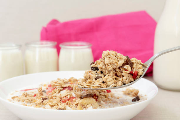 Healthy granola breakfast with slice of apple,raising and milk.