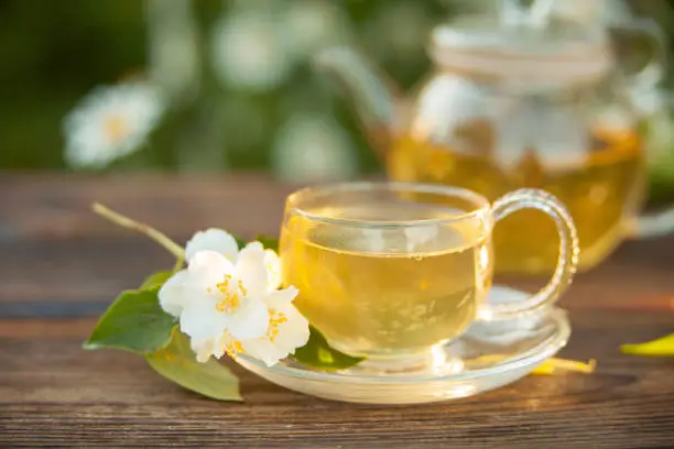 Photo of delicious green tea in beautiful glass bowl on table