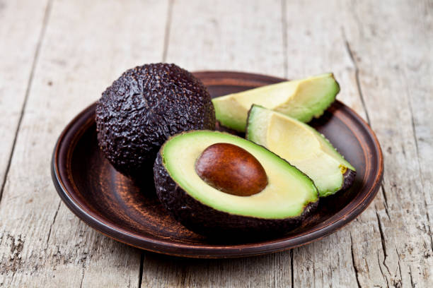 istock Fresh organic avocado on ceramic plate on rustic wooden table background. 1146984116
