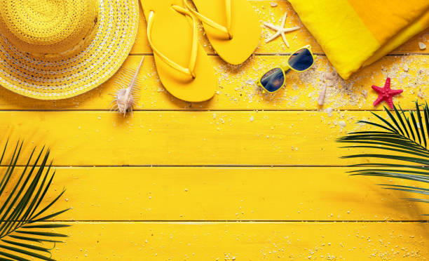 istock Yellow Summer Background With Beach Accessories And Palm Leaves 1146986826
