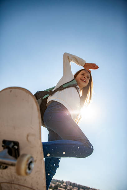 istock Smiling Girl Riding Skateboard Outdoors From Low Angle View 1146994536