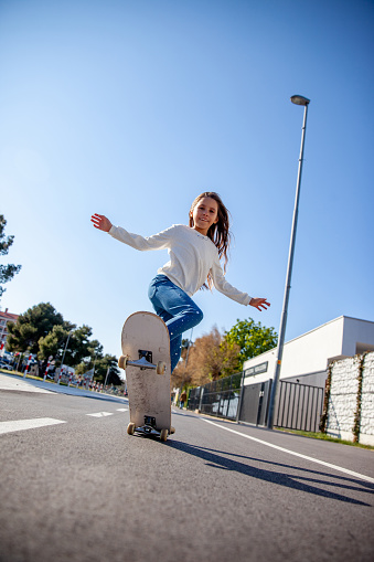 Skateboarding chica joven en calles de la ciudad photo