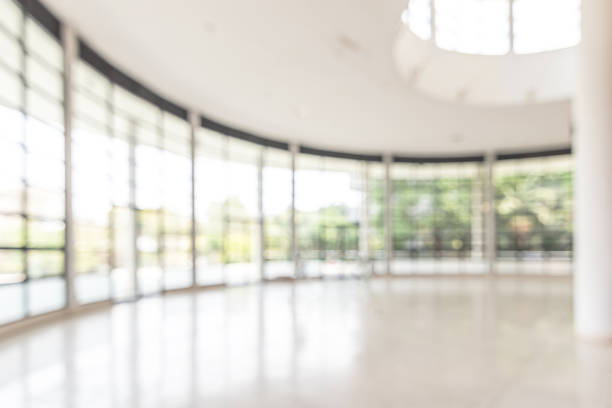 istock Blur background interior view looking out toward to empty office lobby and entrance doors and glass curtain wall 1146995378