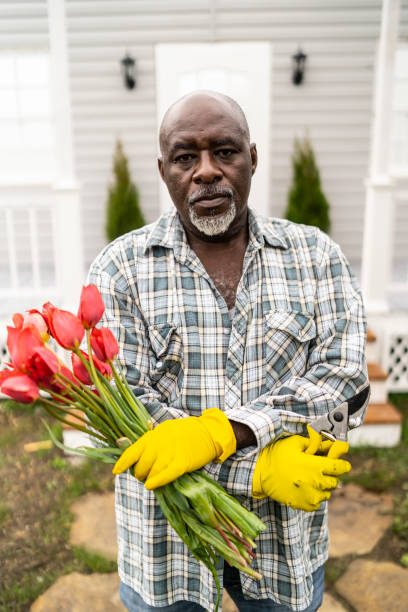 istock African man standing and holding tulips 1146996404