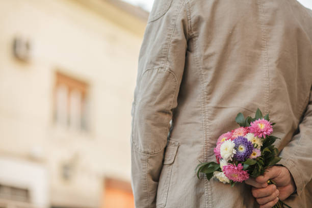 istock Man hiding flower bouquet behind his back 1146996450