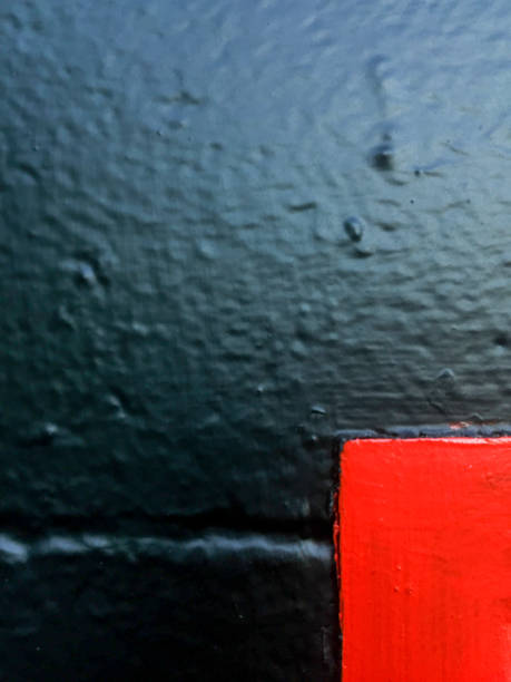 istock Red painted door corner against black painted bricks 1146996847