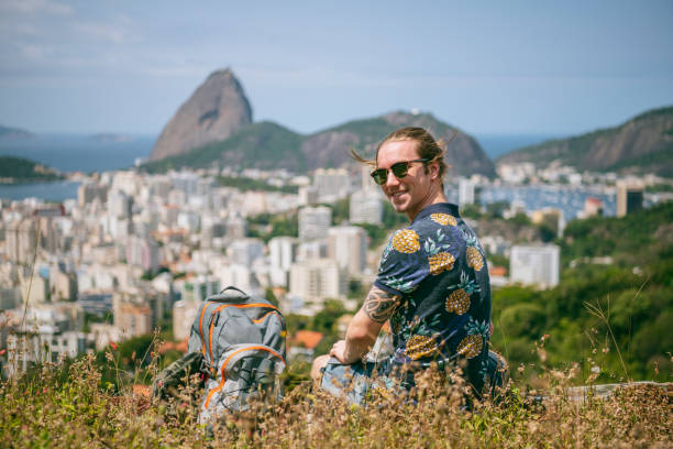 istock Cheerful young man sitting on hill, Rio de Janeiro 1147004244