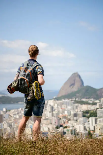 Rear view of young man wearing backpack, on vacation, traveling alone, solitude