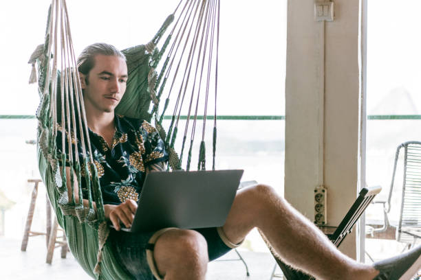 istock Man in hammock working on laptop 1147004258