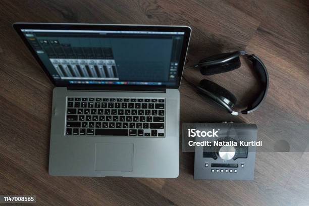 Flat Lay Of Sound Designers Tools On Dark Wood Table Laptop With Mixing Scene Sound Card Headphones Microphone Sound Engineering Tools Professional Sound Card For Music Mixing And Mastering Stock Photo - Download Image Now