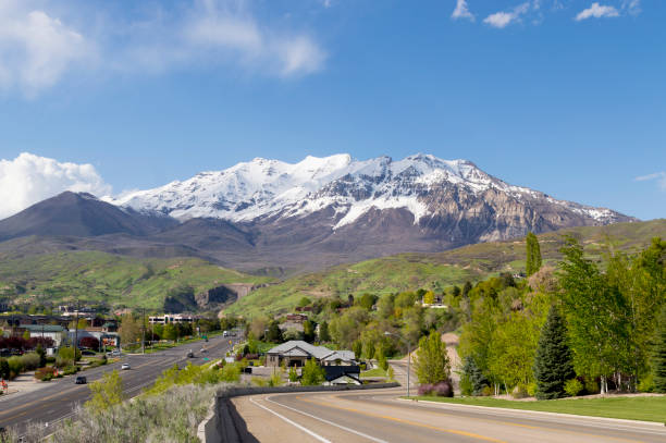 Panoramic View of Snow Covered Mount Timpanogos in Utah Spring This is a panoramic shot showing Mount Timpanogos in Utah's Wasatch Mountains range.  Mt. Timpanogos is a tall landmark in Utah County, ajoining many of the cities including Provo.  This shot was taken during a wet spring season with the base of the mountain looking very green and the peak covered in snow. provo stock pictures, royalty-free photos & images