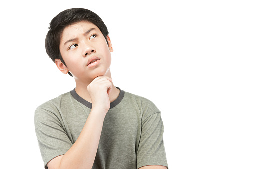 Portrait Young Asian boy over white background, be upset; have a bad temper emotional portrait of teen boy wearing t-shirt. Thoughtful teenager, isolated on white background.