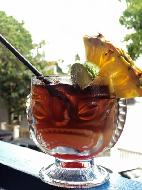 Maui Mai Tai served in drinking glass shaped like Hawaiian god, balcony overlooking Lahaina downtown Maui Mai Tai served in drinking glass shaped like Hawaiian god, balcony overlooking Lahaina downtown. mai tai hawaii stock pictures, royalty-free photos & images