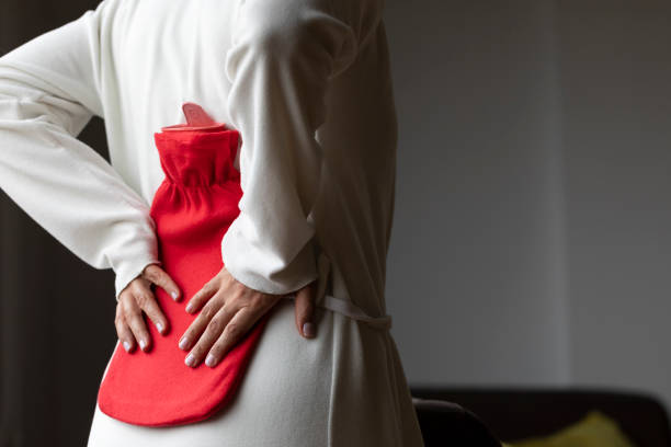 Unhealthy young woman with stomachache using a hot water bag.