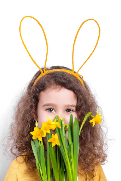 istock Girl with bunny ears with flowers on a light background. 1147033949
