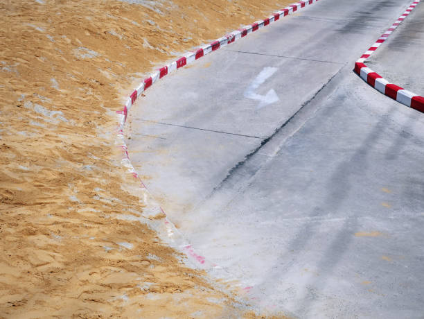 istock High Angle View of Curved Road with Unfinished Footpath Construction 1147034300