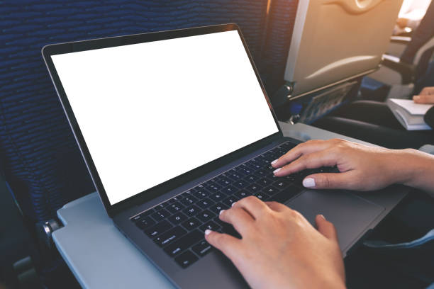 istock a woman using and typing at laptop computer with blank white desktop screen while sitting in the cabin 1147038595