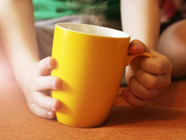 istock Cup of tea in children's hands 1147047928