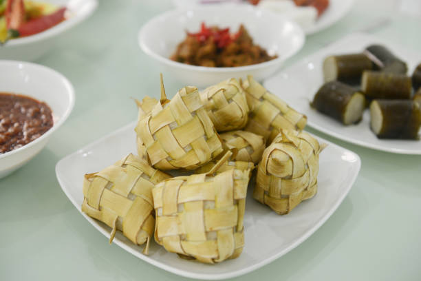 Rice cake inside woven coconut leaves or Ketupat served on the dining table