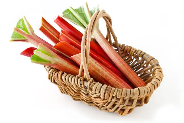 Rhubarb and basket against white background close up