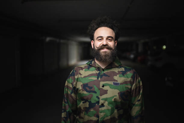 istock Smiling bearded hipster in a military jacket 1147055385