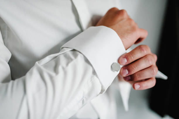 istock Hand's groom wears a metallic silver cufflinks stud. Wedding morning. 1147059519