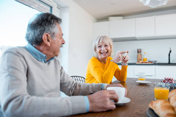 istock Married caucasian couple eating breakfast and laughing 1147061944