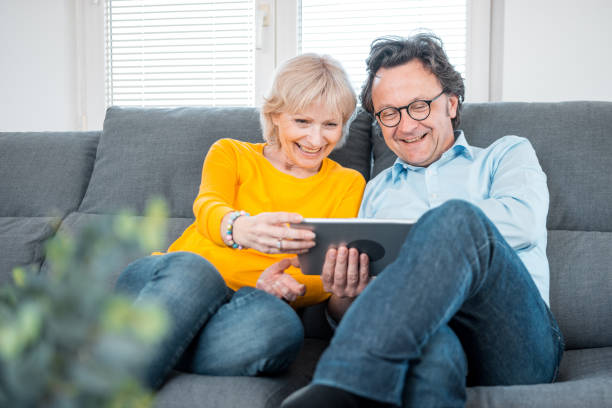 istock Mature caucasian couple sitting on the sofa and using a digital tablet 1147062037