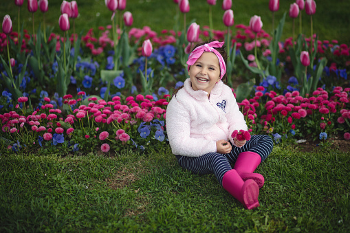 Cute and beautiful young girl enjoying the Spring day outdoors in the city.