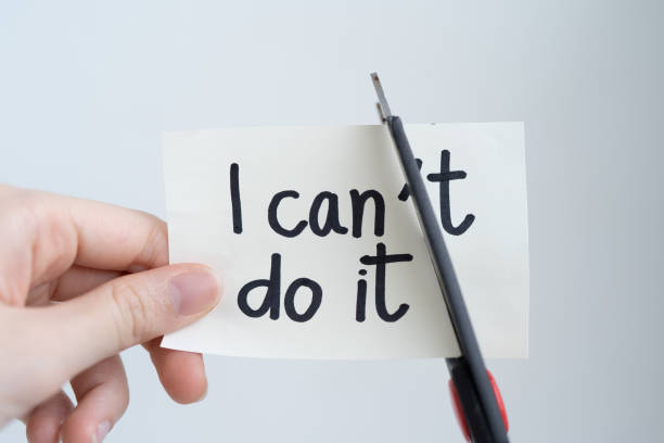 istock Woman hand cutting paper note with scissors to remove T word from I can't do it texts isolated on white background. Positive attitude, self belief and motivation concept. 1147063867