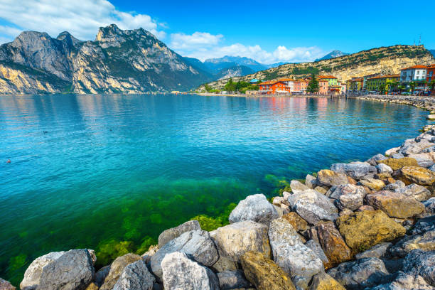 istock Lake shore with rocks and mountains in background, lake Garda 1147064520