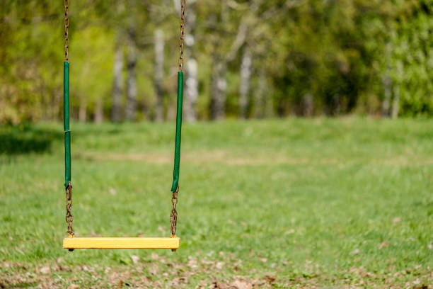 istock Old chain swing in the sun in the spring park 1147064558