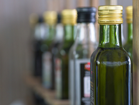 Bottles of extra virgin olive oil  in a row on a table