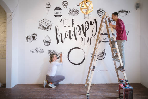 istock Cheerful artists painting a wall at home 1147064891