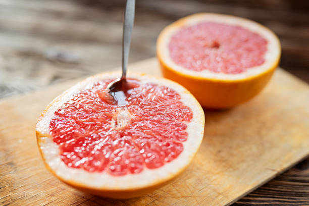 Fresh juicy half a grapefruit with a spoon stock photo