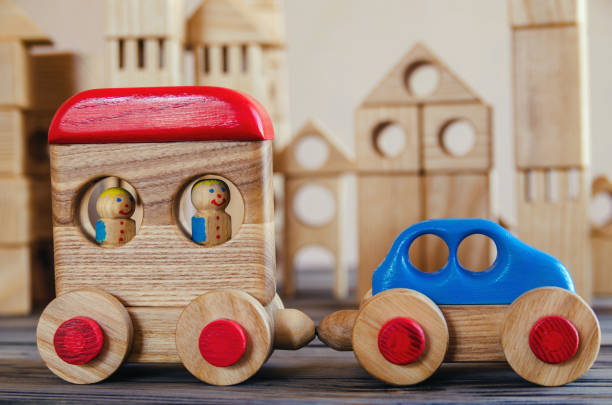 Wooden toy train with one carriage on wooden table with white background and copy