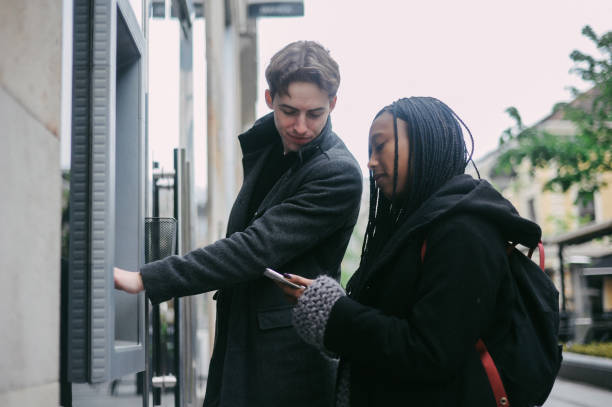 istock Young couple withdrawing money from the ATM 1147065443