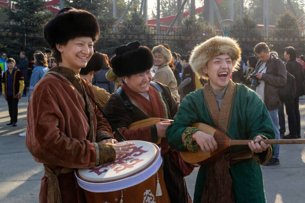 Street musicians in national costumes play folk instruments - a drum and a dombra during a holiday Almaty, Kazakhstan - March 21, 2019. Street musicians in national costumes play folk instruments - a drum and a dombra during a holiday kazakhstan photos stock pictures, royalty-free photos & images