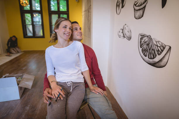 istock Cute smiling couple looking at their illustration on the wall 1147066857