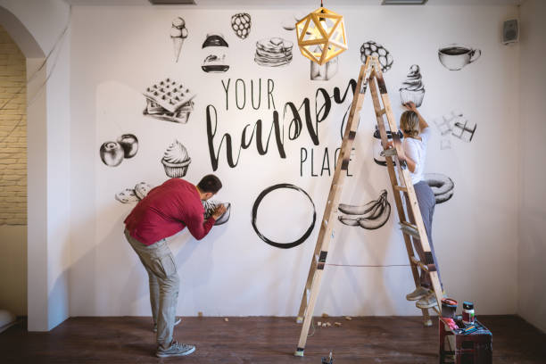 istock Hardworking artists painting a wall together 1147069225