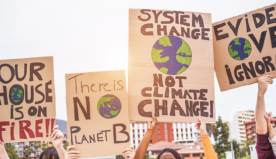 Grupo de manifestantes en carretera, jóvenes de diferente cultura y lucha por la raza para el cambio climático-concepto de calentamiento global y medioambiente-enfoque en banners photo