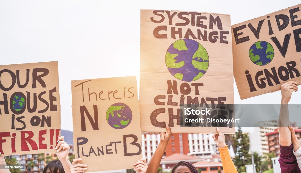 Grupp demonstranter på väg, unga människor från olika kulturer och tävlings kamp för klimat förändringar-global uppvärmning och miljö koncept-fokus på banners - Royaltyfri Klimatförändring Bildbanksbilder