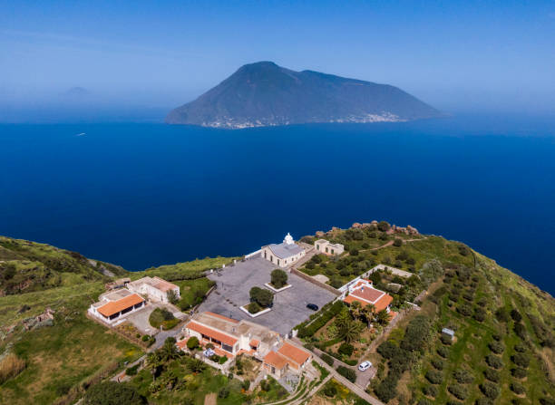 Aerial view of the church in the village of Quattropani on the Lipari island with a Salina island in the background Aerial view of the church in the village of Quattropani on the Lipari island with a Salina island in the background, Italy salina sicily stock pictures, royalty-free photos & images