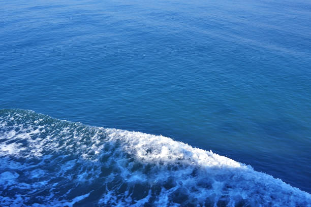 sea ocean water surface with wave foam trail beside yacht