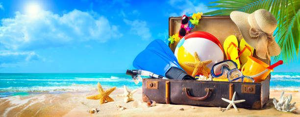 Beach accessories in suitcase on sand. Family holidays concept Preparation for summer vacation. Beach accessories in suitcase on sand. Family holidays concept scuba diving family stock pictures, royalty-free photos & images